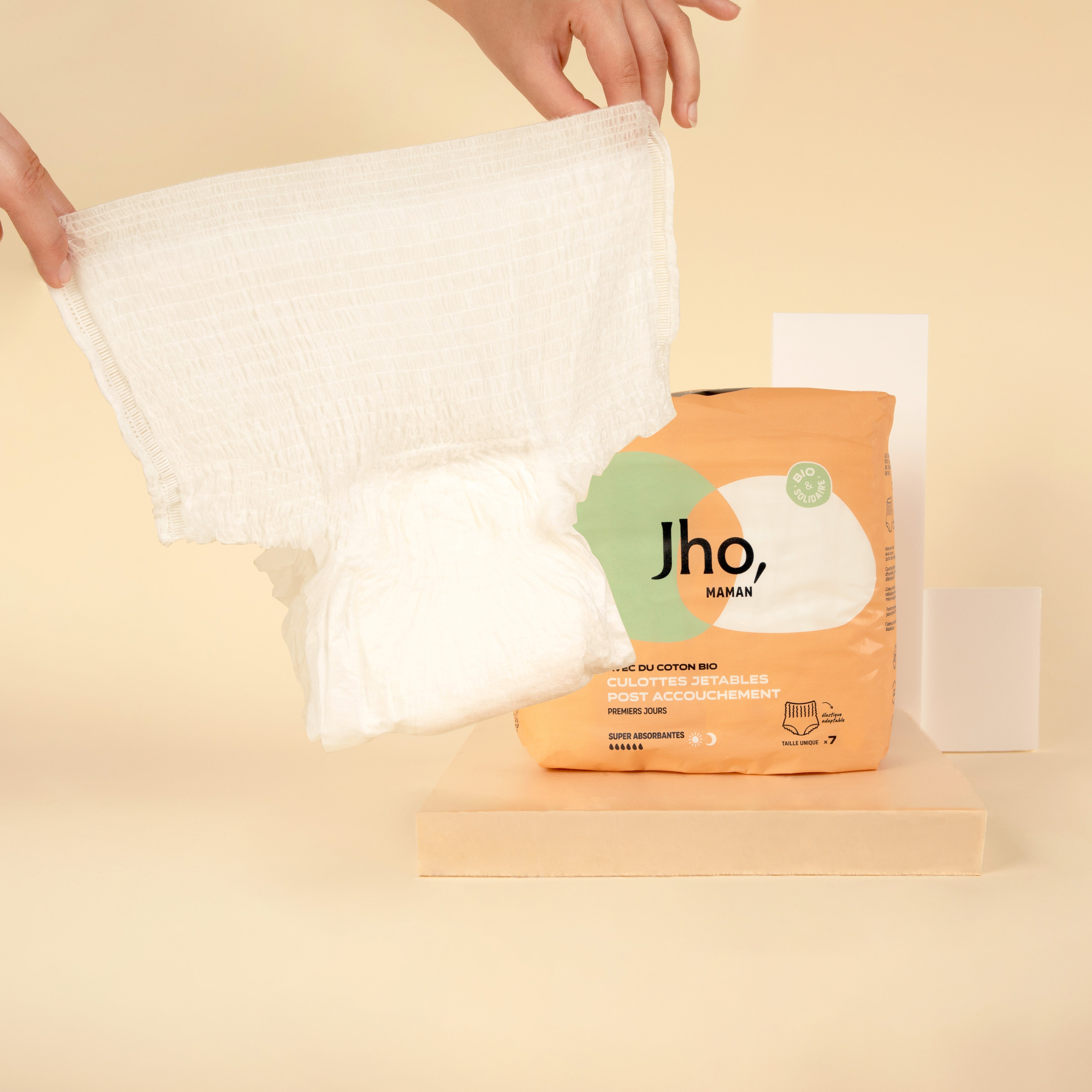 Culotte jetable post-accouchement dépliée avec pack de 7 sur la droite