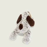 Bouillotte peluche en forme de chien allongé. Poils gris et marron et museau beige