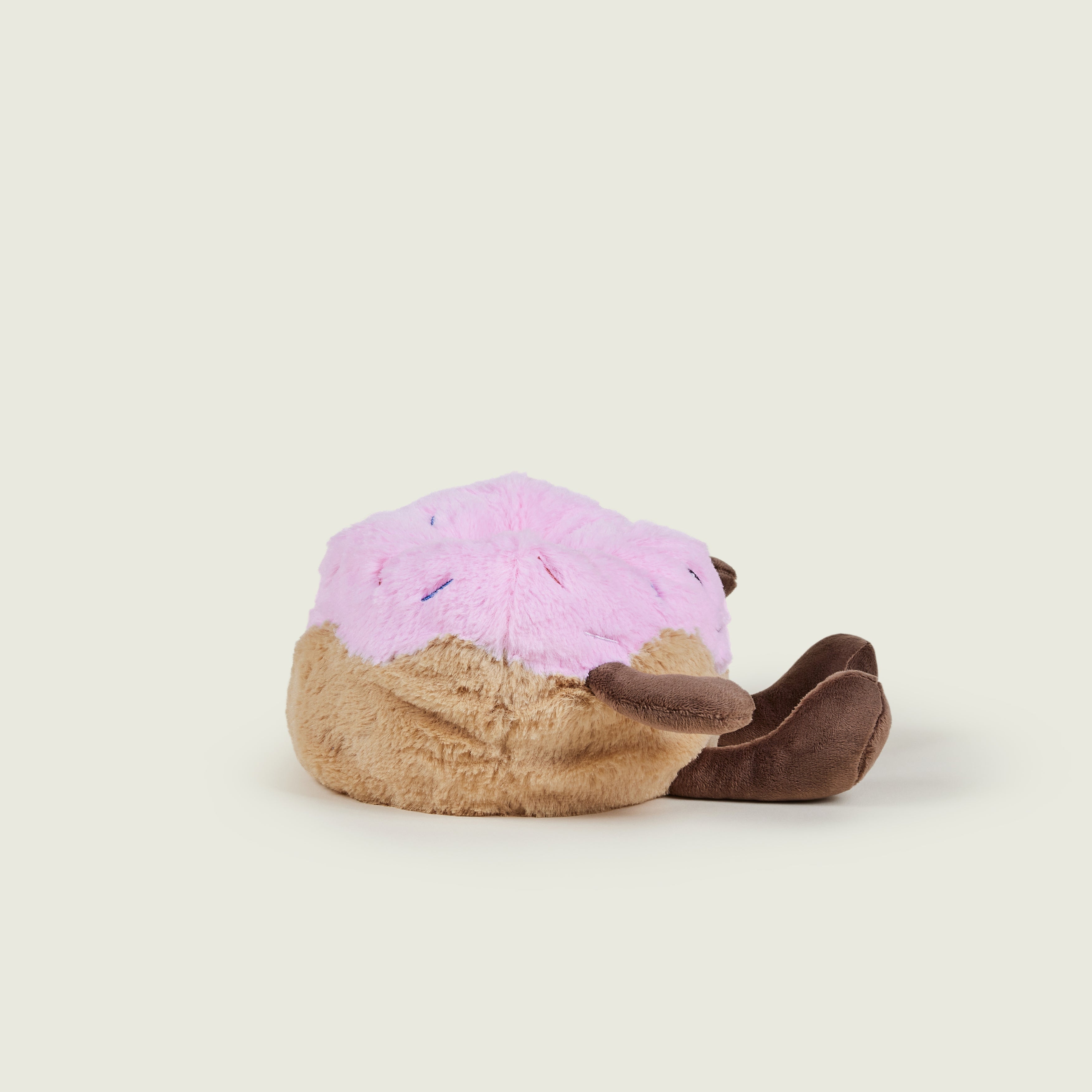 bouillotte peluche en forme de donut's rose et marron avec visage, jambes et bras, sur le profil droit