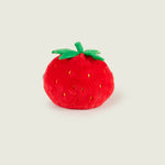 Bouillotte peluche en forme de fraise, rouge avec sur le haut deux feuille et une tige verte. Elle a un visage avec un sourire, des bras et des jambes marron. Elle est de dos