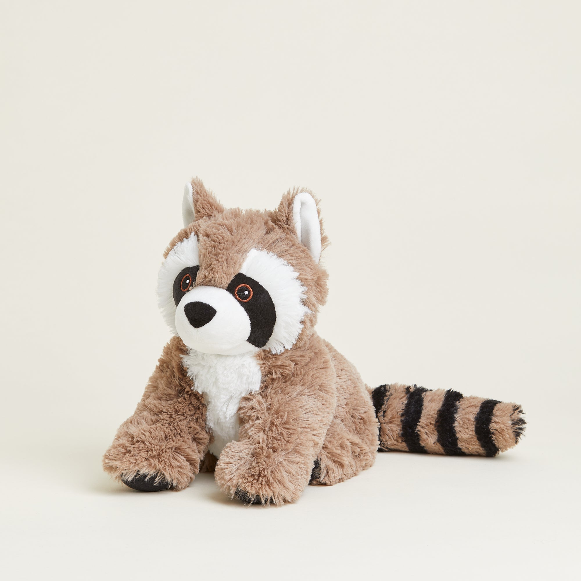 Bouillotte peluche en forme de raton laveur. Pelage marron et noir et tête blanche. Position assise. Queue rayée noire et marron. 