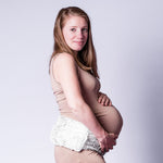 Femme enceinte portant autour de sa taille une ceinture bouillotte de la marque armies