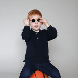 Paire de lunettes de soleil bébé catégorie 4, bicolore moutarde et blanc avec monture en TPEE effet transparent. Mise en situation portée