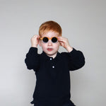 Paire de lunettes de soleil bébé catégorie 4, bicolore moutarde et blanc avec monture en TPEE effet transparent. Mise en situation portée avec vue rapprochée