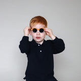 Paire de lunettes de soleil bébé catégorie 4, bicolore moutarde et blanc avec monture en TPEE effet transparent. Mise en situation portée avec vue rapprochée