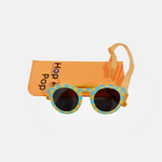 Lunette de soleil pour enfant à monture ronde motif vichy bleu et jaune et son cordon, posée devant leur étui de rangement en feutrine orange marqué "Hop'Pop".