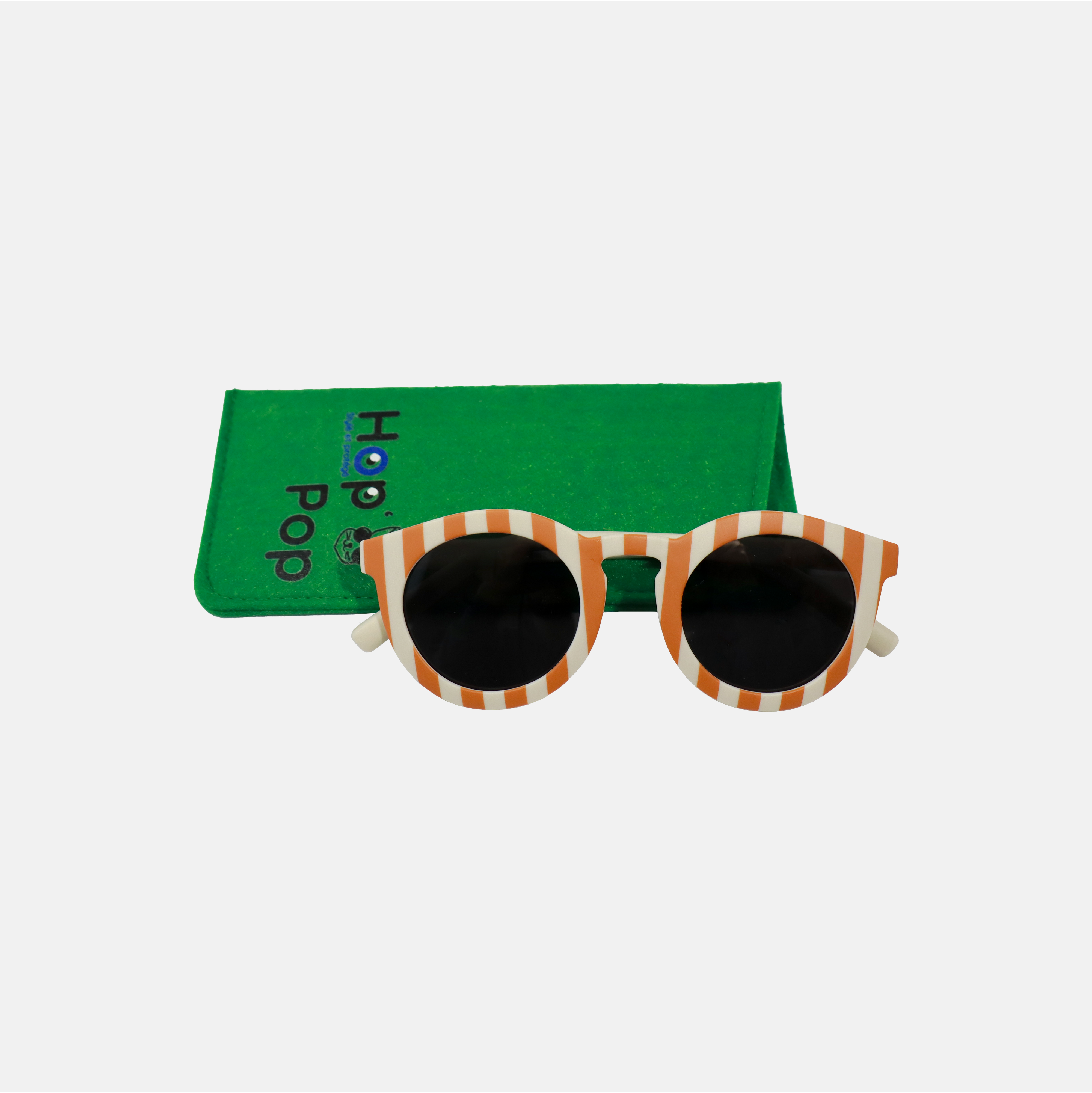 Lunette de soleil pour adulte à monture ronde motif rayée rouge, posée devant leur étui de rangement en feutrine verte marqué "Hop'Pop".