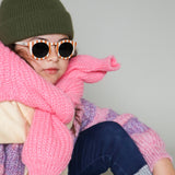 Paire de lunettes de soleil pour enfants catégorie 3, avec monture en TPEE rayée crème et brique. Mise en situation portée de profil rapprochée