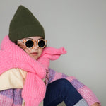 Paire de lunettes de soleil pour enfants catégorie 3, avec monture en TPEE rayée crème et brique. Mise en situation portée de profil