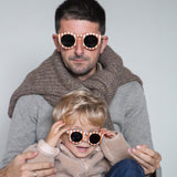 Paire de lunettes de soleil bébé catégorie 4, monture en TPEE blanc avec rayures couleur brique. Mise en situation portée