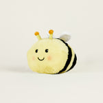 Peluche bouillotte juniors abeille jaune rayée noire, avec visage souriant et positionnée de profil