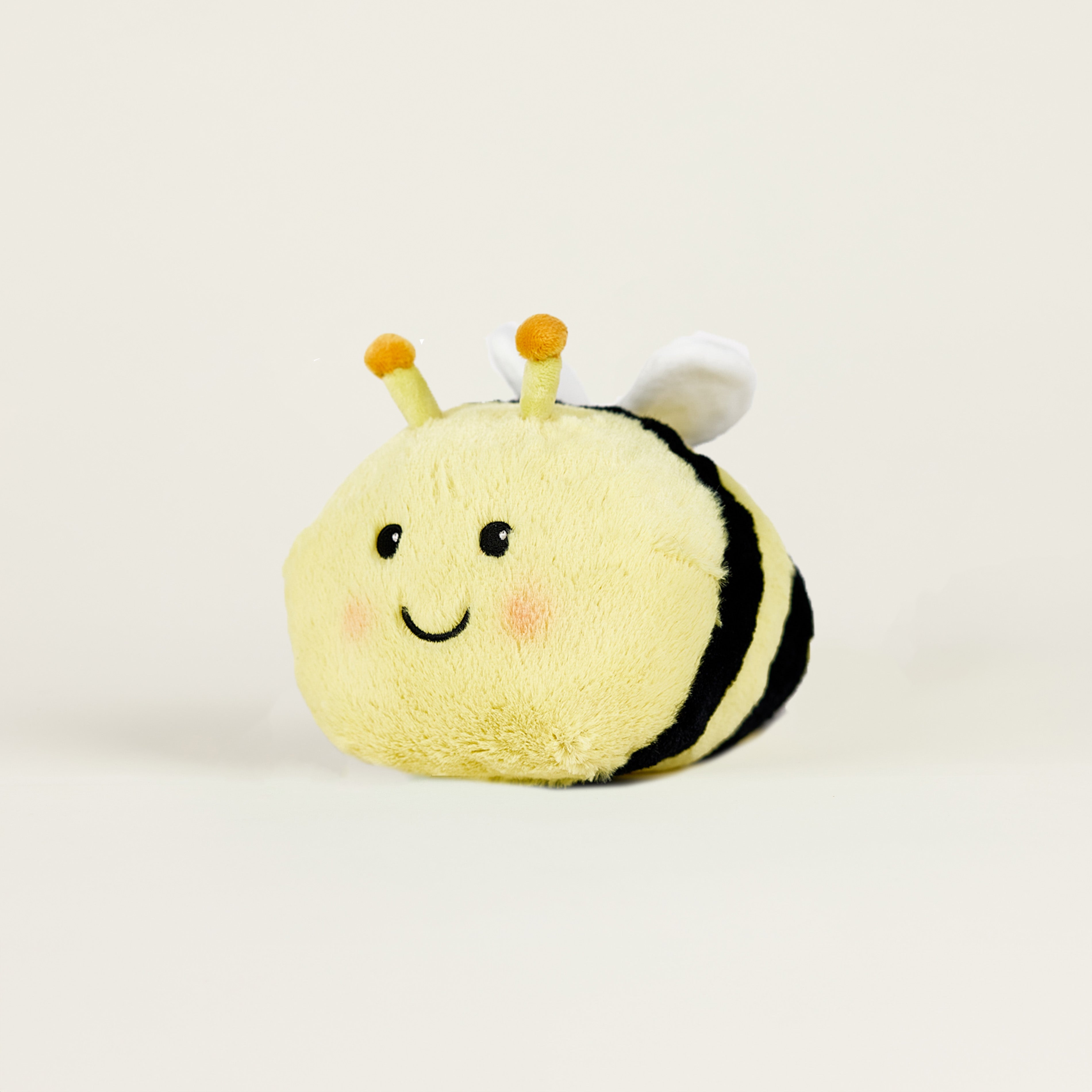 Peluche bouillotte juniors abeille jaune rayée noire, avec visage souriant et positionnée de profil