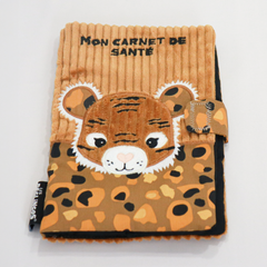 Protège carnet de santé pour bébé Déglingos, modèle tigre. Housse en tissu côtelé marron avec tête de tigre en relief, broderies blanches et noires. Poche à motifs léopard multicolores (noir, beige, orange) et fermeture velcro. Inscription "Mon carnet de santé" brodée en noir sur le dessus. Accessoire doux, original et ludique pour enfant, conforme aux normes CE.