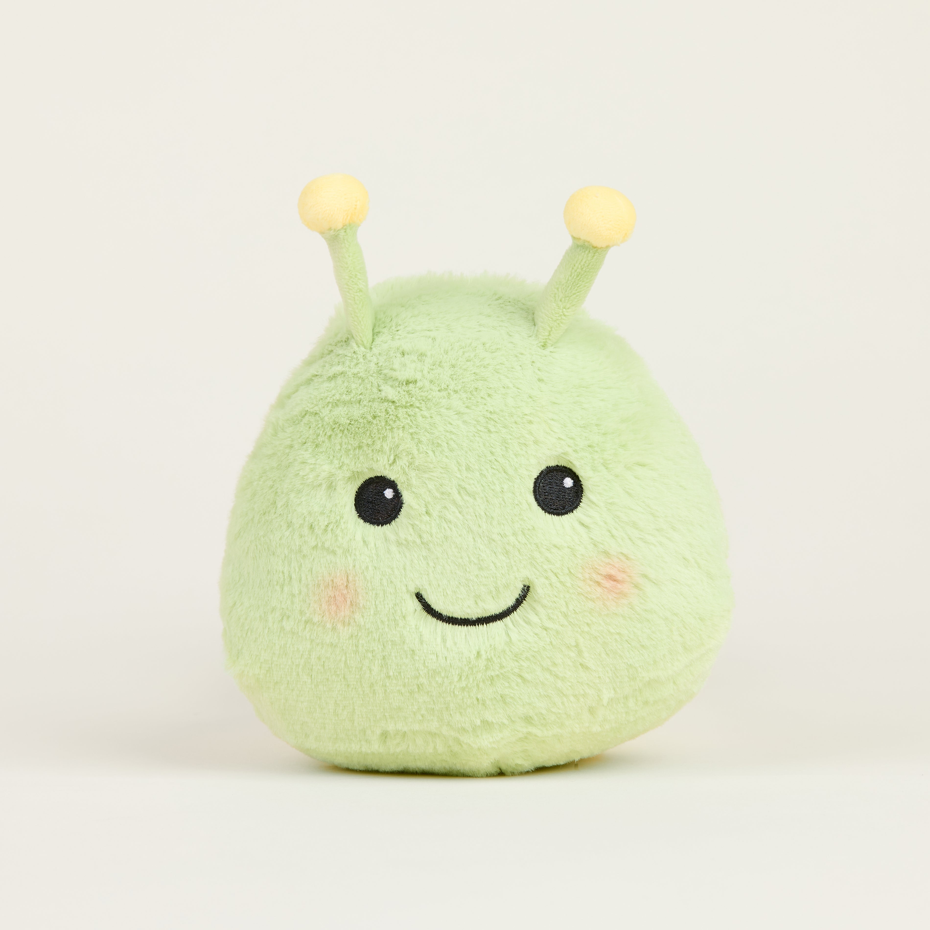 Peluche bouillotte juniors chenille, vert clair avec antennes et visage souriant, vue de face