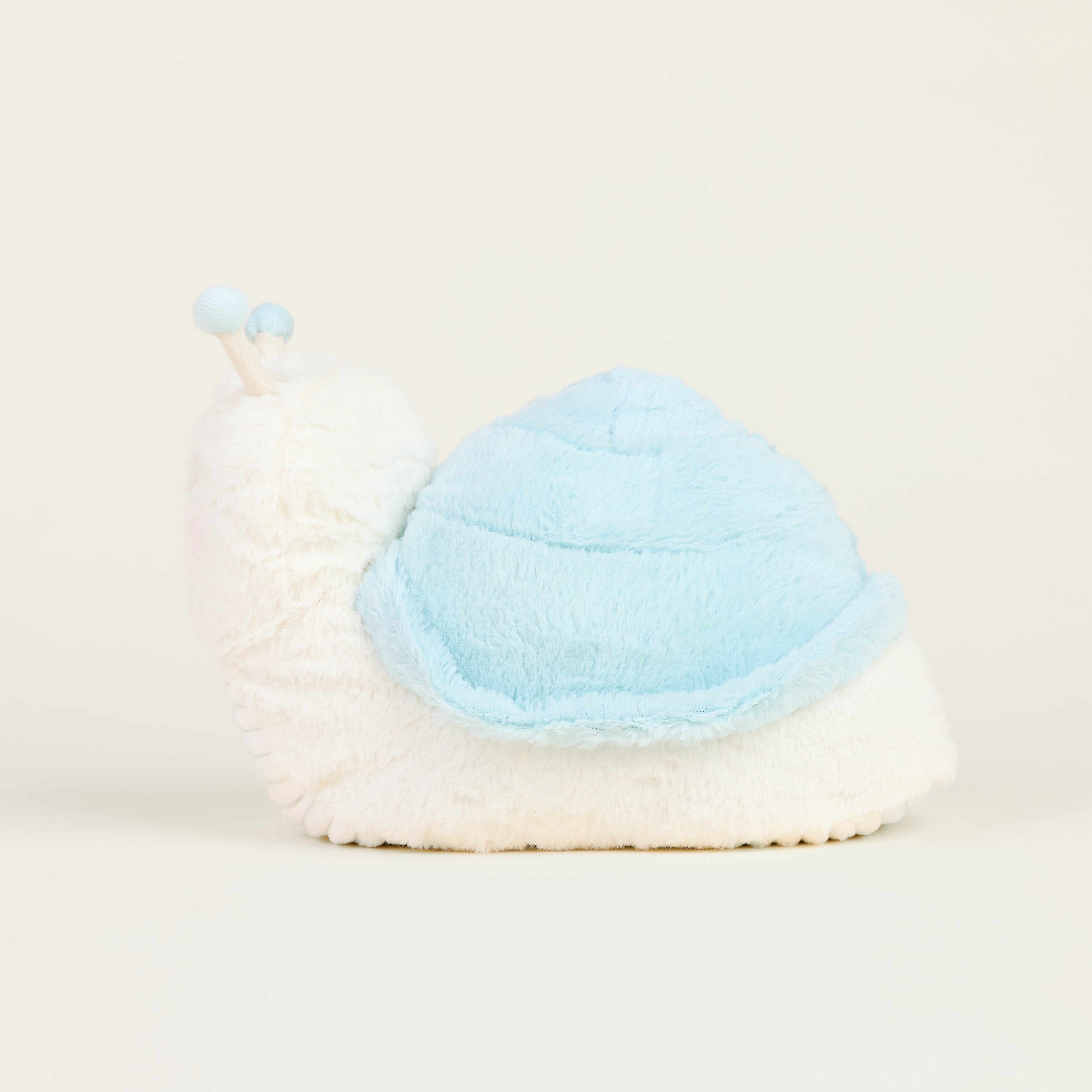 Peluche bouillotte escargot, blanc et bleu pastel, avec antennes et visage souriant, vue latérale