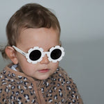 Paire de lunettes de soleil bébé catégorie 4, monture en TPEE blanc en forme de fleur. Mise en situation portée vue rapprochée