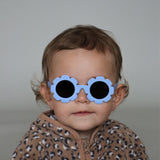 Paire de lunettes de soleil bébé catégorie 4, monture en TPEE bleue en forme de fleur. Mise en situation portée