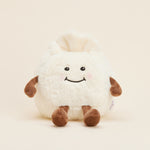 Peluche bouillotte Ravioli personnifié, crème et marron, avec visage souriant, bras et jambes. Vue de face 
