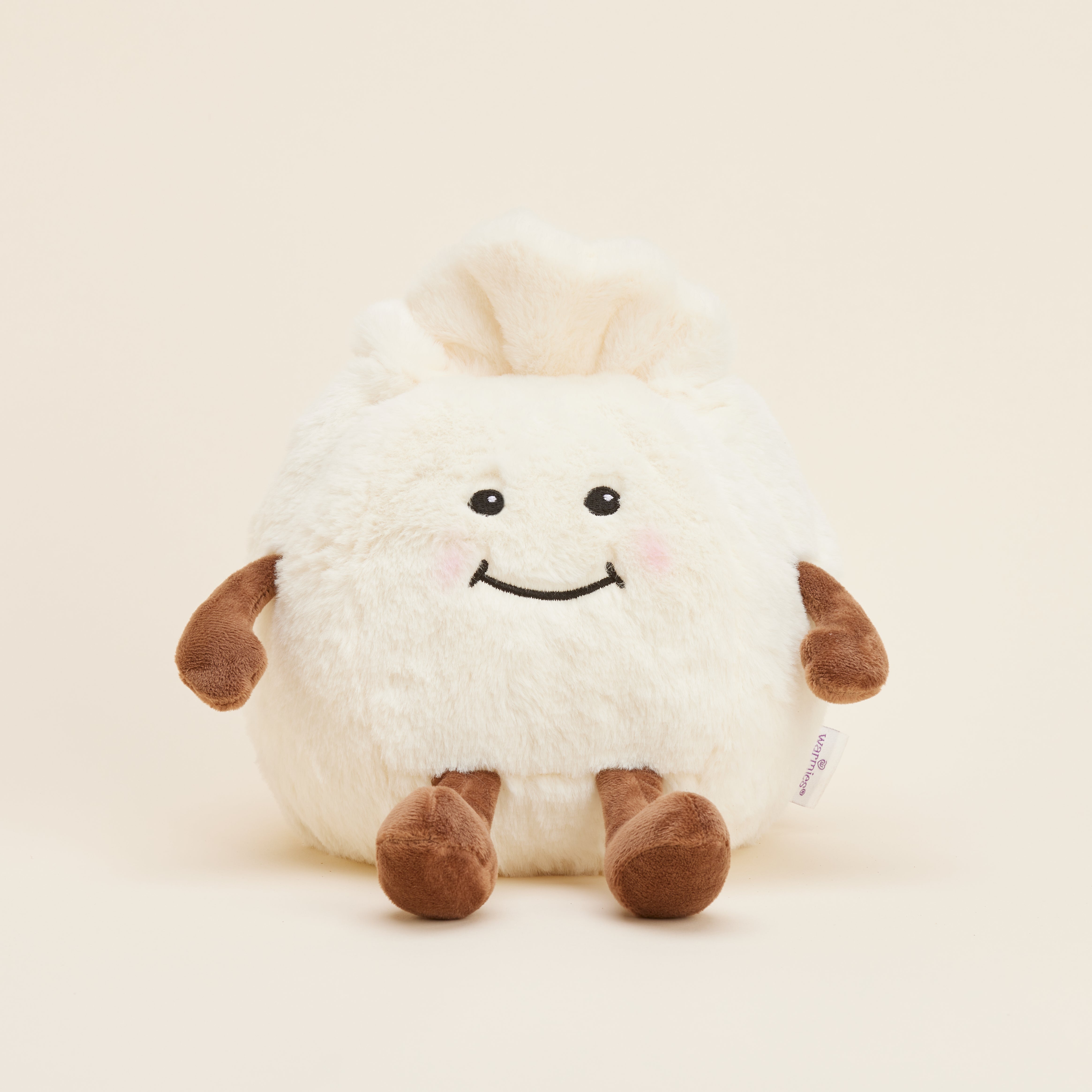 Peluche bouillotte Ravioli personnifié, crème et marron, avec visage souriant, bras et jambes. Vue de face 

