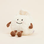 Peluche bouillotte Ravioli personnifié, crème et marron, avec visage souriant, bras et jambes. Vue de profil