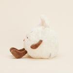 Peluche bouillotte Ravioli personnifié, crème et marron, avec visage souriant, bras et jambes. Vue latérale