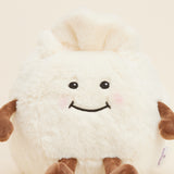Peluche bouillotte Ravioli personnifié, crème et marron, avec visage souriant, bras et jambes. Vue rapprochée du visage